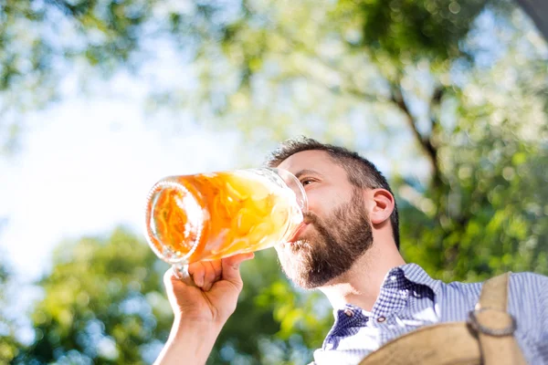 Mannen i traditionella bayerska kläder håller mugg öl — Stockfoto