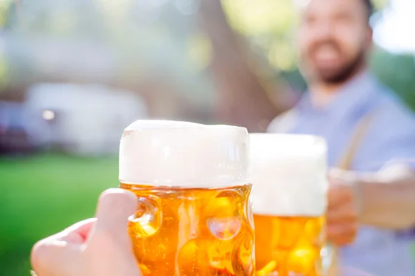 Hombre con ropa bavariana tradicional sosteniendo jarra de cerveza — Foto de Stock