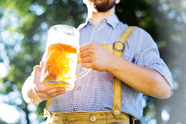 Homem em roupas tradicionais da Baviera segurando caneca de cerveja — Fotografia de Stock