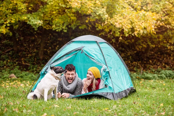 Casal com cão deitado na tenda — Fotografia de Stock