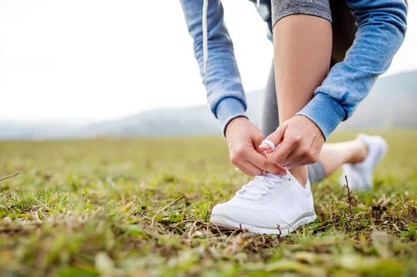 Молодой бегун завязывает шнурки — стоковое фото