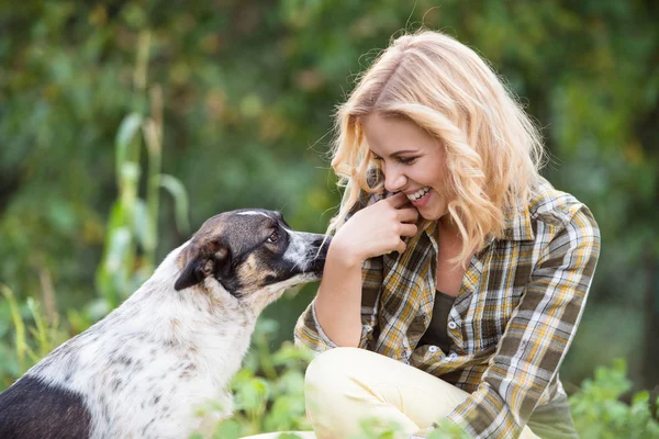 Frau mit Hund im grünen Garten — Stockfoto