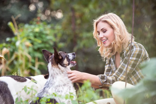 Vrouw met hond in groene tuin — Stockfoto