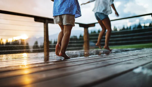 Nerozpoznatelná matka s malou dcerou hrající si na terase dřevěné kabiny, dovolená v přírodě. — Stock fotografie
