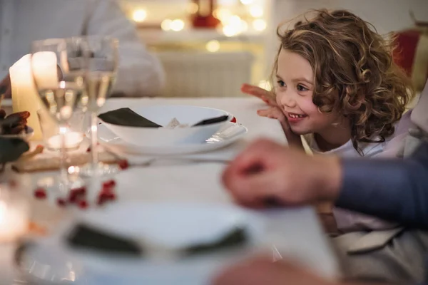 Menina pequena com a família sentada dentro de casa celebrando o Natal juntos. — Fotografia de Stock