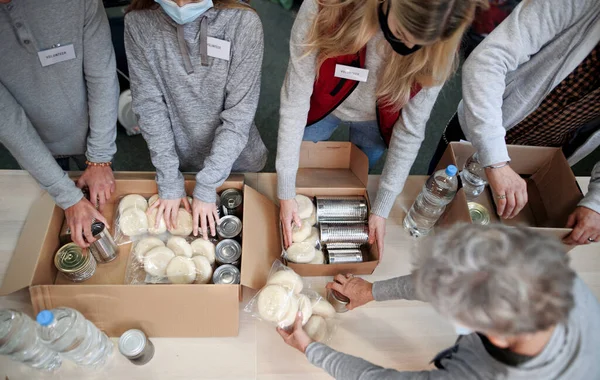 Top view of group of volunteers in community donation center, food bank and coronavirus concept. — Stock Photo, Image