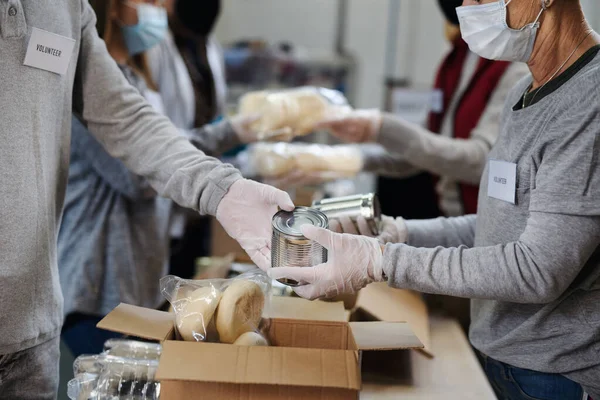 Gruppo di volontari nel centro di donazione della comunità, banca alimentare e concetto di coronavirus. — Foto Stock