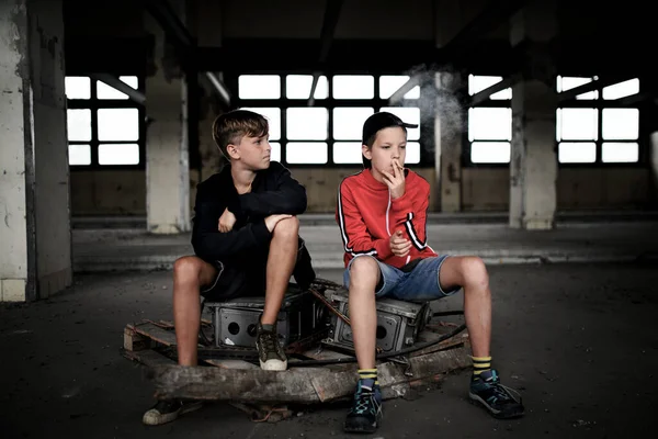 Group of teenagers boys indoors in abandoned building, smoking cigarettes. — Stock Photo, Image