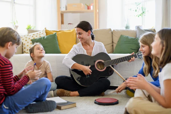 Öğretmenli bir grup evde eğitim gören çocuk içeride müzik dersi alıyor, koronavirüs konsepti. — Stok fotoğraf