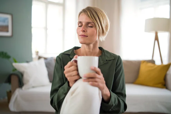 Portrait of woman meditating indoors in office, holding cup of tea. — Stock Photo, Image