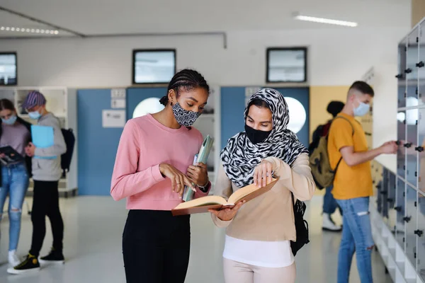 Νέοι φοιτητές φίλοι με μάσκες προσώπου πίσω στο κολέγιο ή το πανεπιστήμιο, έννοια coronavirus. — Φωτογραφία Αρχείου