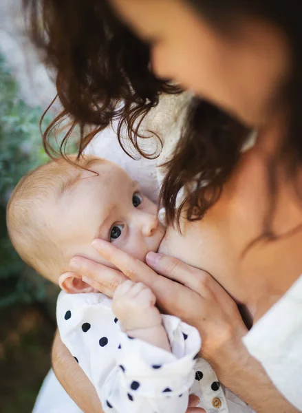 Visão superior da mulher amamentando bebê menina ao ar livre no quintal. — Fotografia de Stock