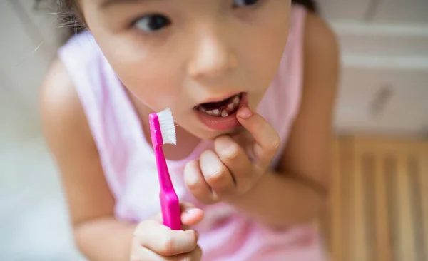 Ovanifrån porträtt av orolig liten flicka inomhus, förlora baby tand. — Stockfoto