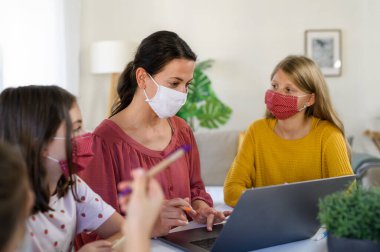 Öğretmenli bir grup evde eğitim gören çocuk kapalı alanda, koronavirüs konsepti.