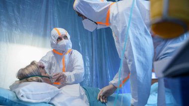 Doktorlar ve kovid 19 hastası hastanede yatakta oksijen maskesi takıyor, koronavirüs konsepti....