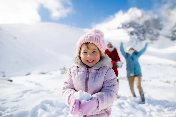 Retrato de menina pequena alegre que joga na neve na natureza de inverno, jogando. — Fotografia de Stock