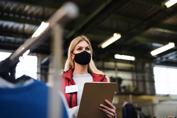 Volunteer working with food and clothes in community charity donations center, coronavirus concept. — Stock Photo, Image