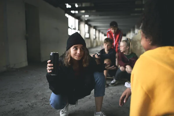 Sekelompok remaja geng duduk di dalam gedung yang ditinggalkan, menggunakan smartphone. — Stok Foto