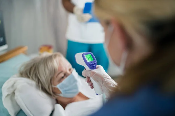 Läkare och covid-19 infekterade patienter i sängen på sjukhus, coronavirus och mätning temperatur koncept. — Stockfoto