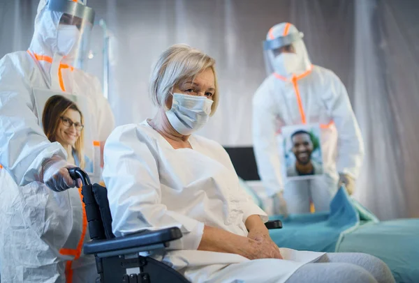 Médecins et patient infecté par le covidé-19 en fauteuil roulant à l'hôpital, concept de coronavirus. — Photo