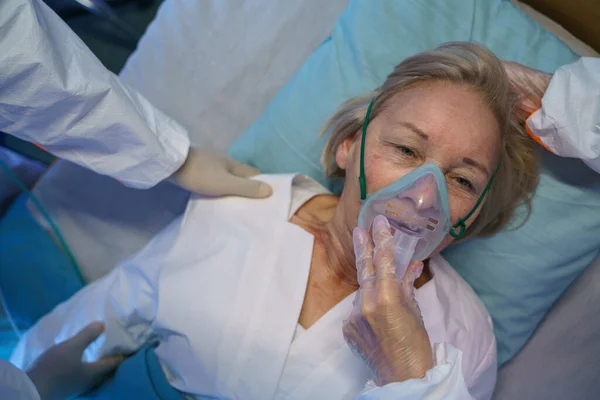 Bovenaanzicht van covid-19 patiënt met zuurstofmasker in bed in ziekenhuis, coronavirus concept. — Stockfoto