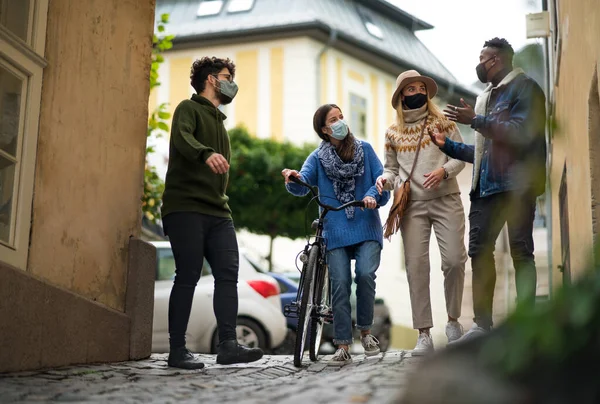 Группа молодых людей с велосипедом на открытом воздухе в городе, прогулки. Коронавирусная концепция. — стоковое фото