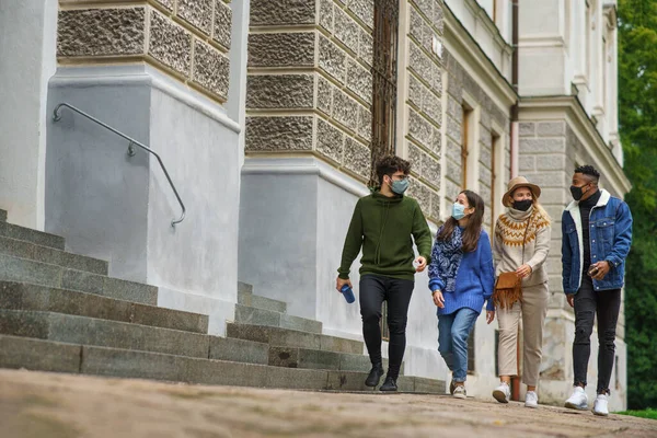 Grupo de jóvenes con mascarilla al aire libre en la ciudad, caminando. Concepto de Coronavirus. —  Fotos de Stock