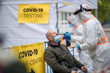 Sokakta, Coronavirus 'ta, CV19 test merkezinde kıdemli bir adam..