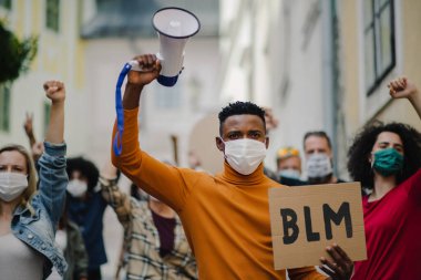 Sokaklarda protesto yapan bir grup aktivist, BLM gösterileri ve koronavirüs konsepti.