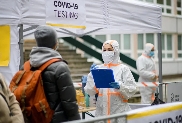 Люди, ожидающие в центре тестирования на коронавирус Ковид-19 на улице. — стоковое фото