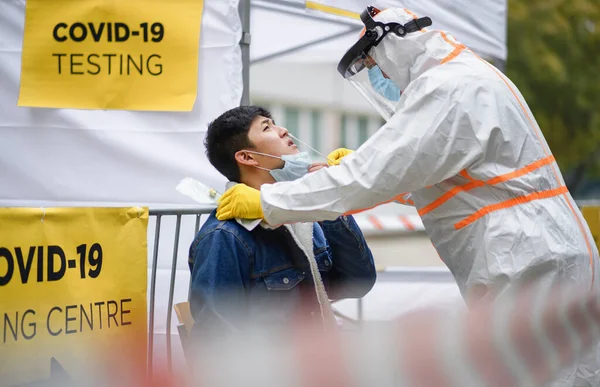 Joven en el centro de pruebas covid-19 al aire libre en la calle, coronavirus y tomando el concepto de hisopo. —  Fotos de Stock