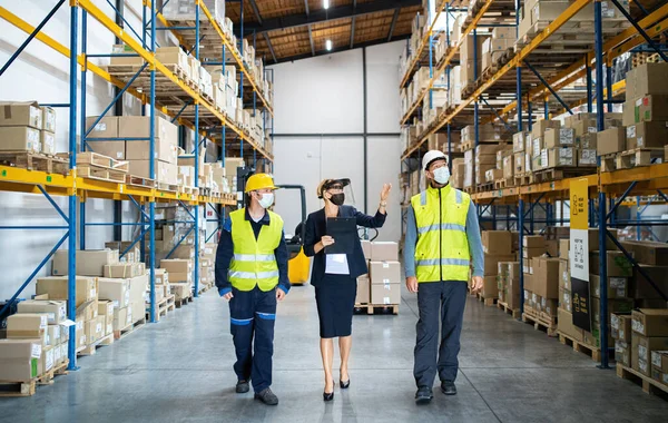 Gruppe von Arbeitern mit Manager, die im Lager arbeiten, Coronavirus-Konzept. — Stockfoto