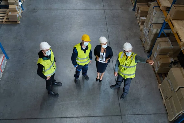 Vista dall'alto del gruppo di lavoratori con manager che lavorano all'interno del magazzino, concetto di coronavirus. — Foto Stock