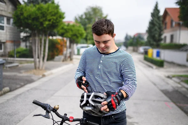 Portrait of down syndrome adult man with bicycle standing outdoors on street. — Stock Photo, Image