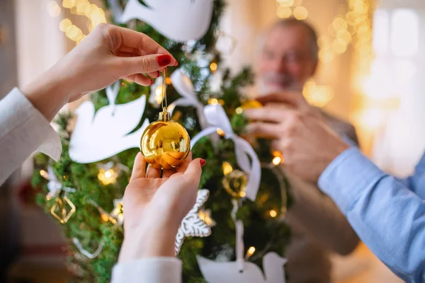Familiares irreconhecíveis dentro de casa em casa no Natal, árvore de decoração. — Fotografia de Stock