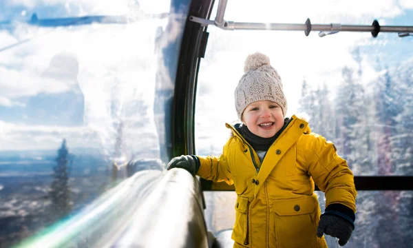 Küçük bir çocuğu teleferik kulübesinde görmek. Karlı kış günlerinde tatil.. — Stok fotoğraf