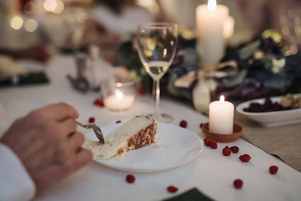 Onherkenbare man binnen aan tafel tijdens kerstdiner, taart etend. — Stockfoto