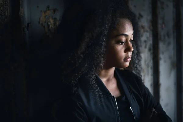 Retrato de triste menina adolescente mestiça em pé dentro de casa em prédio abandonado. — Fotografia de Stock