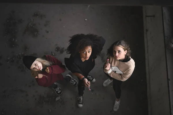 Вид зверху групи дівчат-підлітків банди в приміщенні в покинутій будівлі, дивлячись на камеру . — стокове фото
