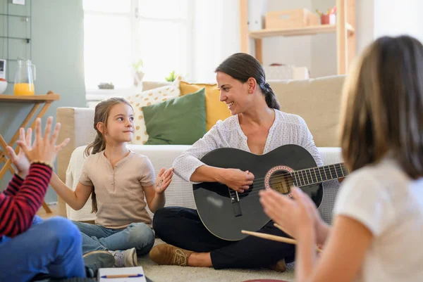 Gruppe von Hausschulkindern mit Lehrer, die drinnen Musikunterricht haben, Coronavirus-Konzept. — Stockfoto