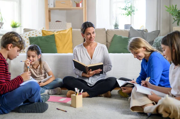 Groep van thuis onderwijs kinderen met leraar studeren binnen, coronavirus concept. — Stockfoto