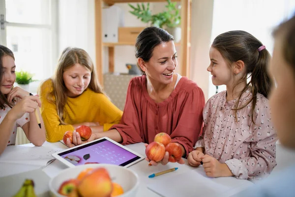 Grupp av hemskolebarn med lärare som studerar inomhus, coronavirus koncept. — Stockfoto