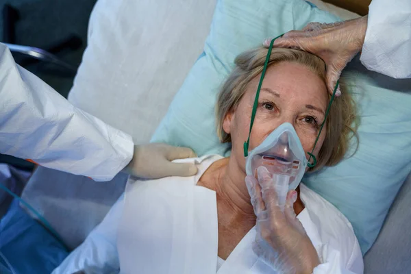 Bovenaanzicht van covid-19 patiënt met zuurstofmasker in bed in ziekenhuis, coronavirus concept. — Stockfoto