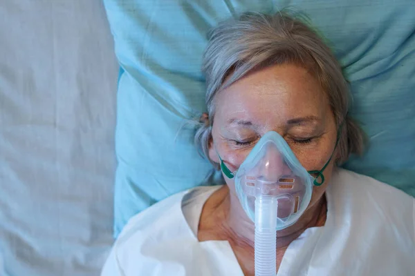 Bovenaanzicht van covid-19 patiënt met zuurstofmasker in bed in ziekenhuis, coronavirus concept. — Stockfoto