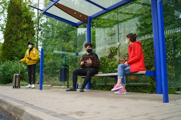 Les jeunes qui parlent en bus s'arrêtent à l'extérieur en ville. Concept de coronavirus. — Photo