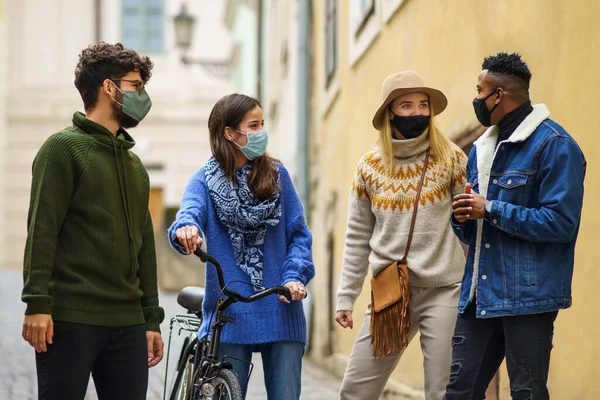 Grupo de jovens com bicicleta ao ar livre na cidade, caminhando. Conceito de coronavírus. — Fotografia de Stock