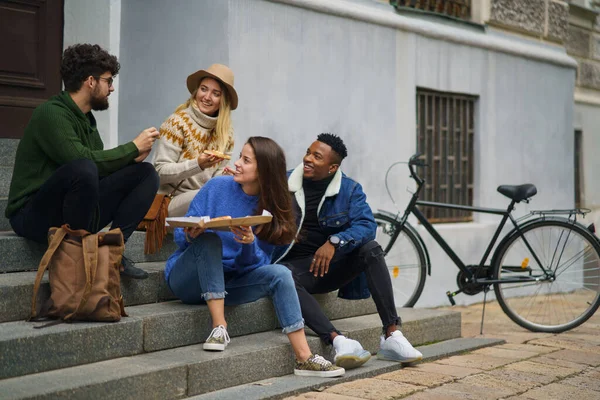 Grupo de jovens ao ar livre na cidade, comendo pizza. Conceito de coronavírus. — Fotografia de Stock