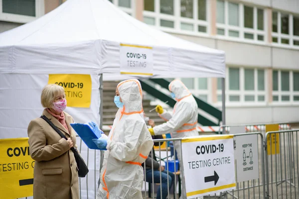 Caddedeki covid-19 test merkezinde kıdemli bir adam. Coronavirus ve pamuklu çubuk konsept alıyor.. — Stok fotoğraf