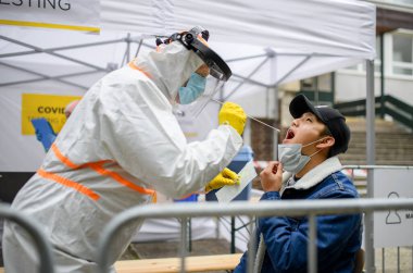 Sokakta, Coronavirus 'ta, covid-19 test merkezinde genç bir adam..