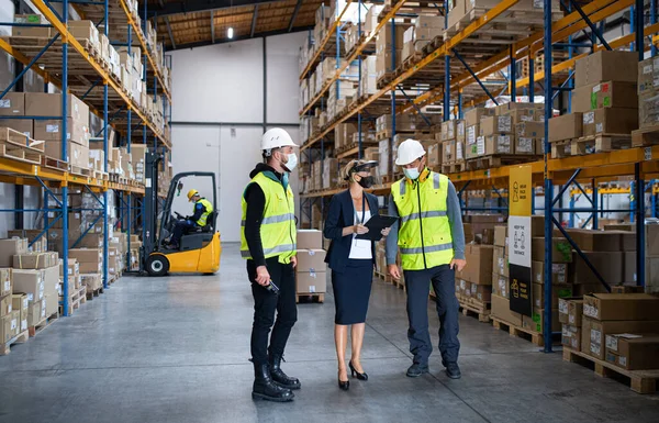 Grupo de trabajadores con gerente trabajando en interiores en almacén, concepto coronavirus. — Foto de Stock